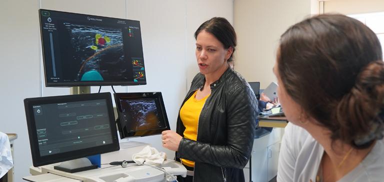 faculty teaching student ultrasound equipment