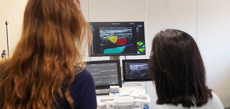 faculty teaching student diagnostic ultrasound equipment